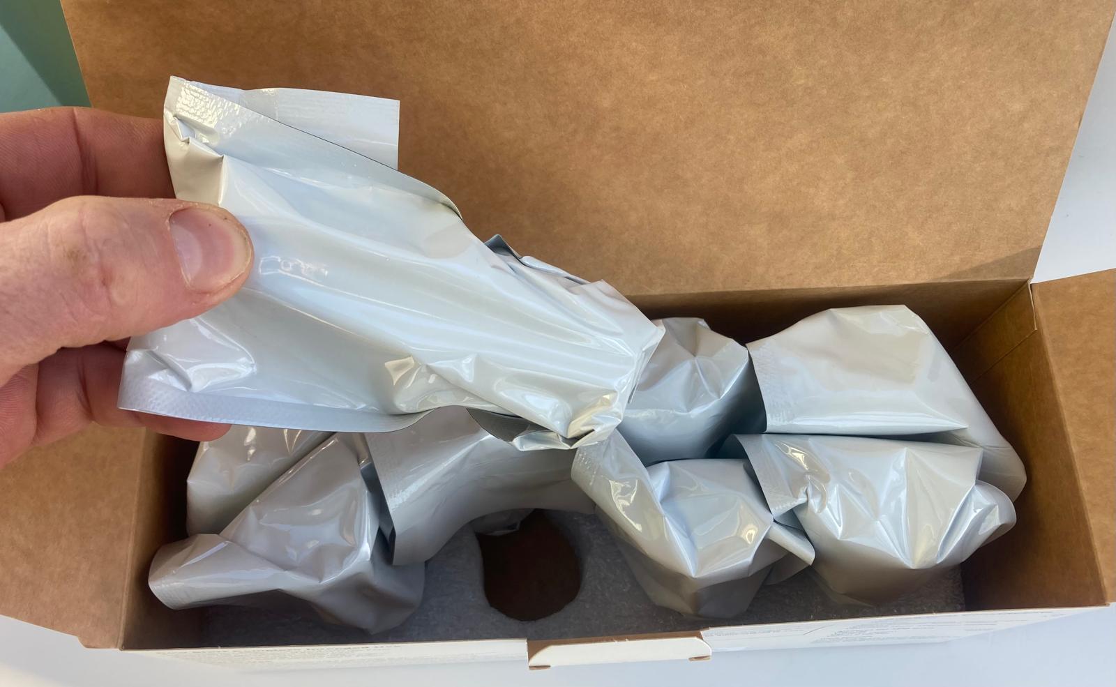 Unboxing Cowstart complete boluses with sealed bolus packages in cardboard box and protective foam inlay.