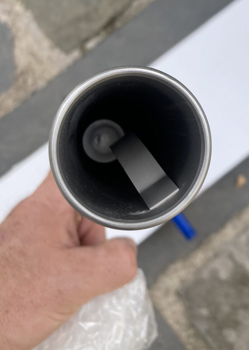 Person holding metal tube, viewed from above.